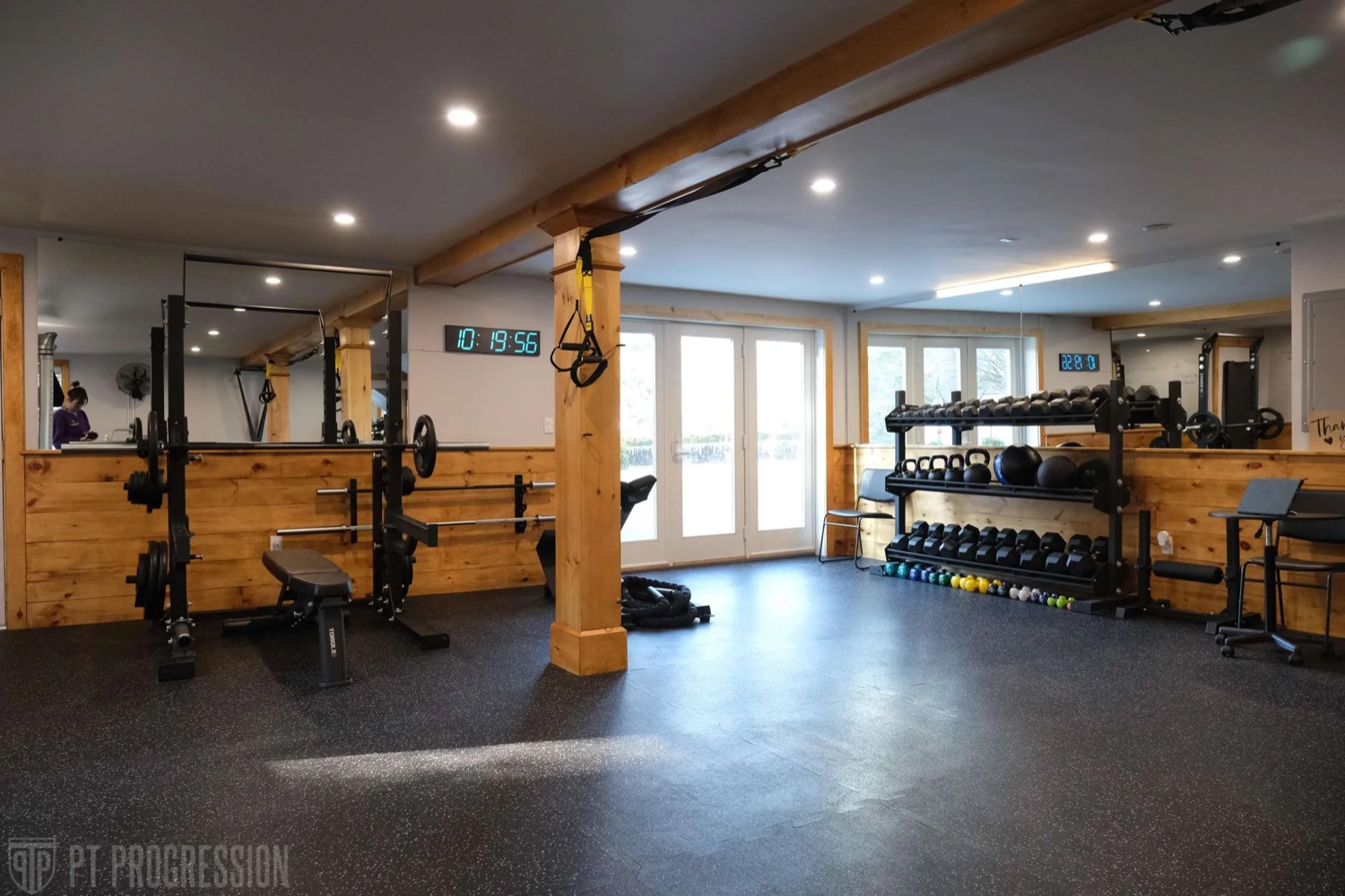 The PT Progression training floor — wood accents, natural light, professional equipment