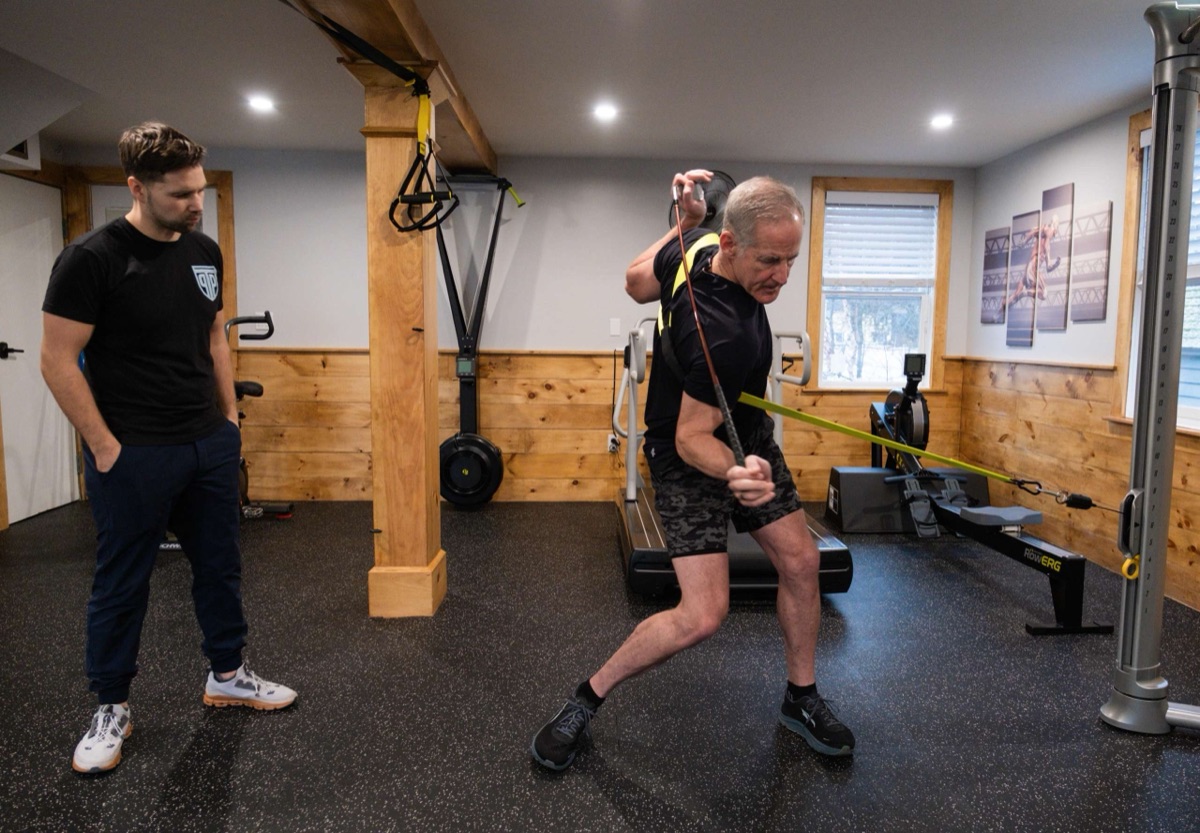A golfer working through a resisted rotational drill with a PT Progression clinician