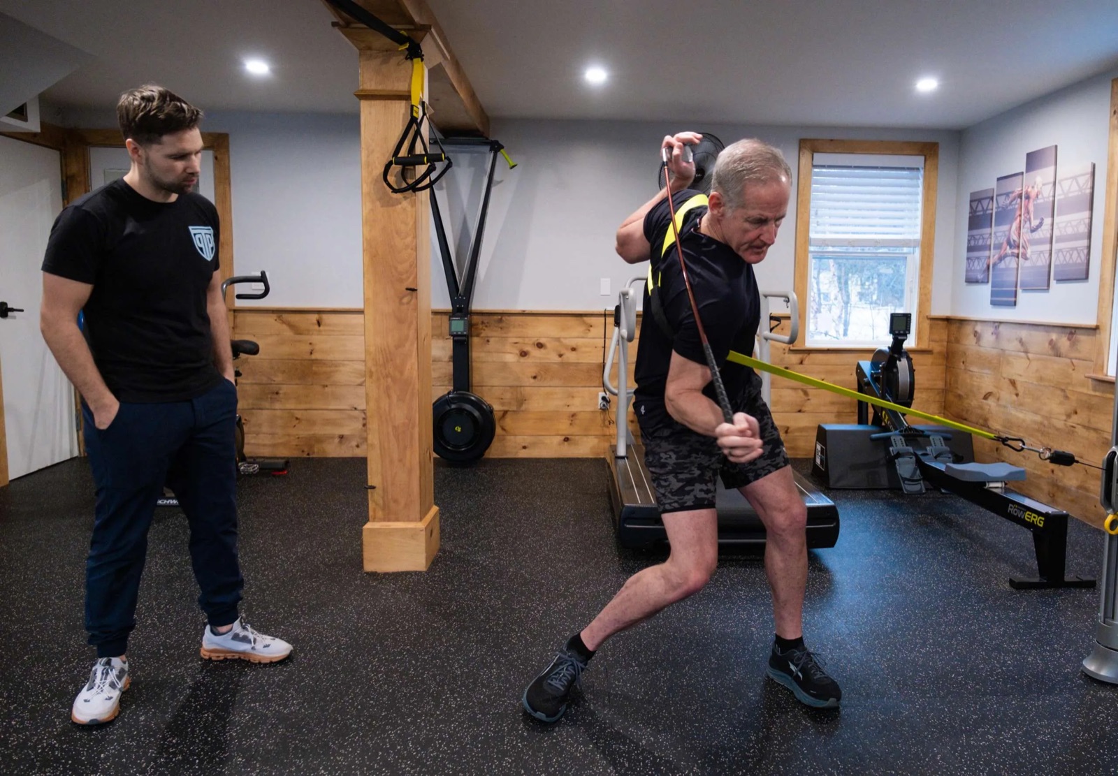 A PT Progression clinician coaching a golfer through a resisted movement in the training studio