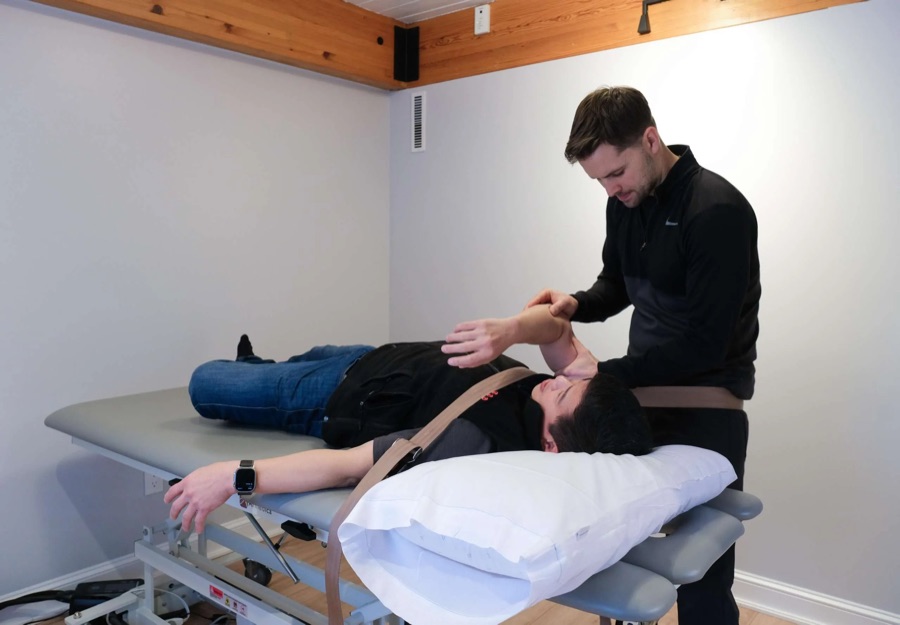 A doctor of physical therapy performing hands-on treatment on a client
